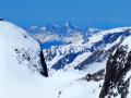 En toile de fond le massif du Vercors avec les Deux Sœurs et la Grande Moucherolle. On devine, minuscules,  trois randonneurs au Col des Aiguilles d'Arves